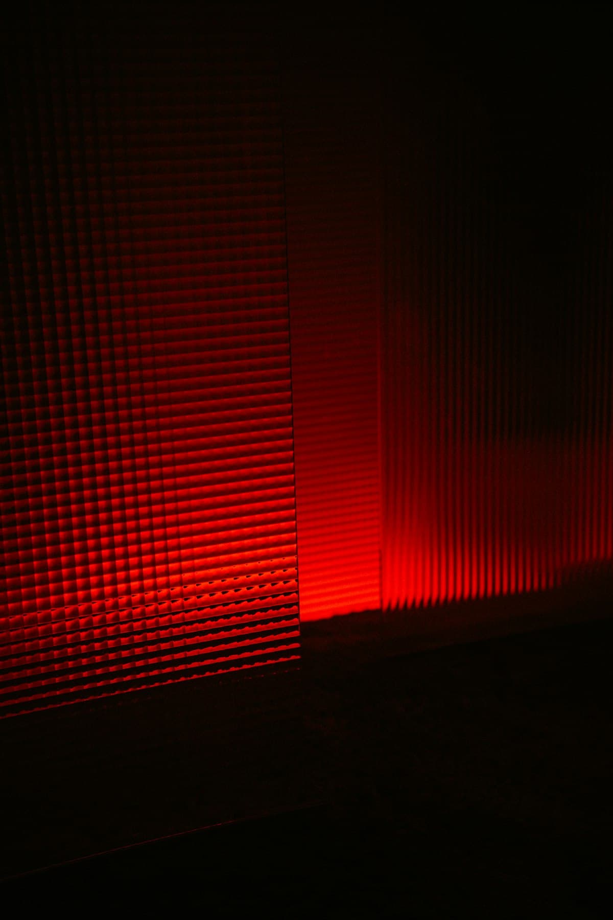 Red light beam illuminating a minimalist wall