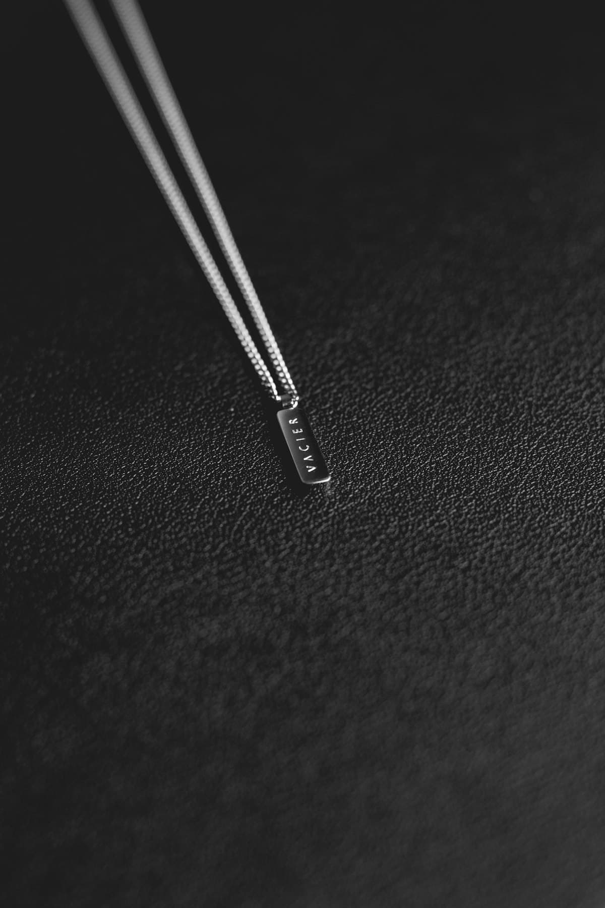 Single surgical instrument photographed against dark textile
